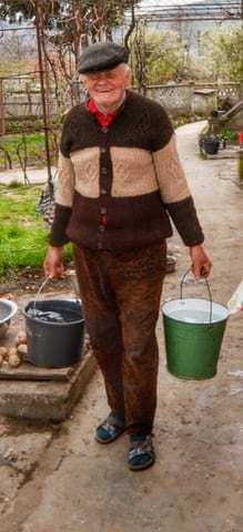 Dad carrying a couple of buckets of water